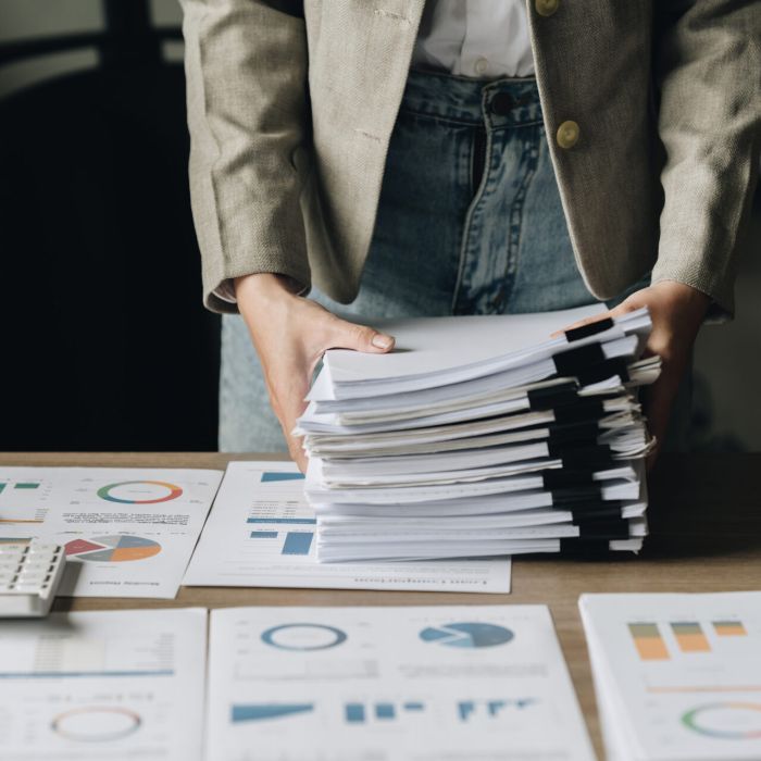 Businesswoman with many financial document to audit budget of company. tax, bill, account concept Businesswoman with many financial document to audit budget of company. tax, bill, account concept.